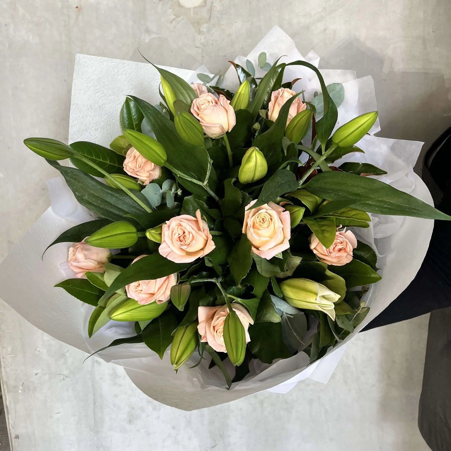 Mother's Day flower delivery arrangement with peach roses and greenery, from a florist near me.