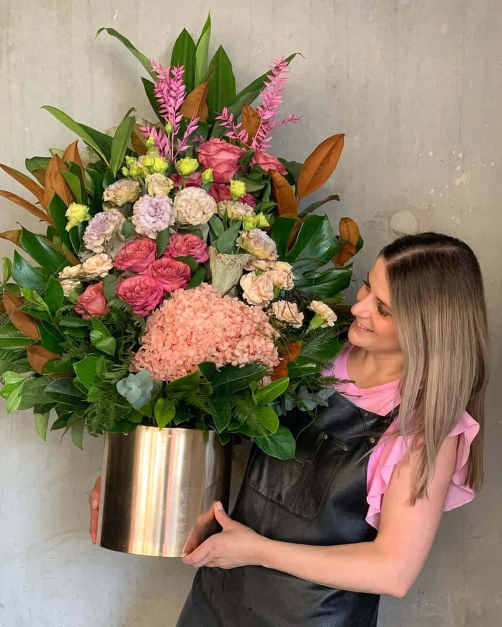 Florist Near me | Violeta's Choice Vase Arrangement with vibrant flowers and greenery, held by a smiling florist in Berwick.