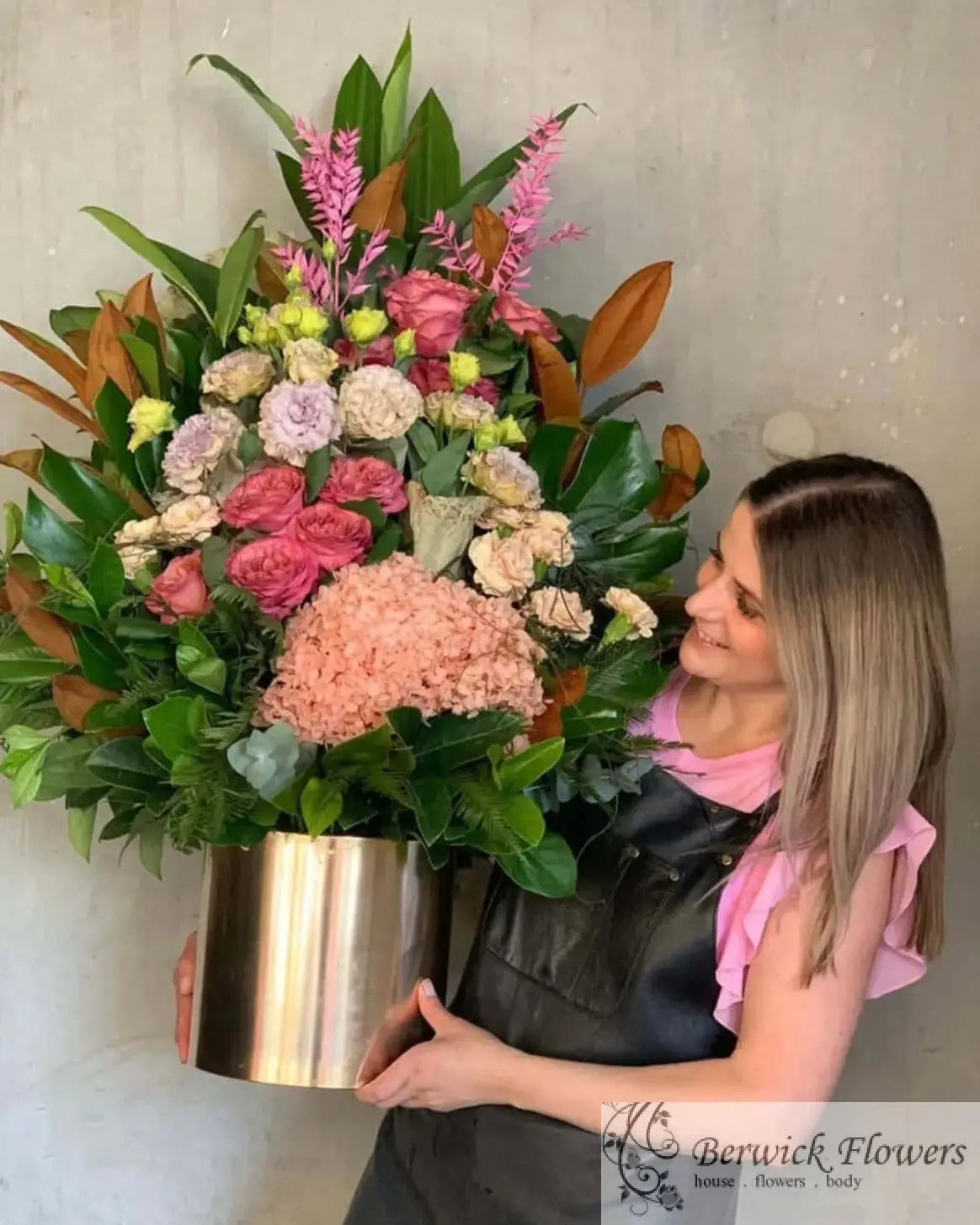 Florist Near me | Violeta's Choice Vase Arrangement with vibrant flowers and greenery, held by a smiling florist in Berwick.