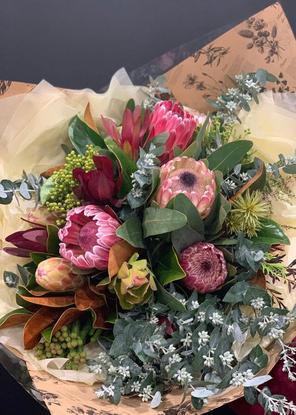 Bouquet of flowers wrapped in brown paper with floral patterns