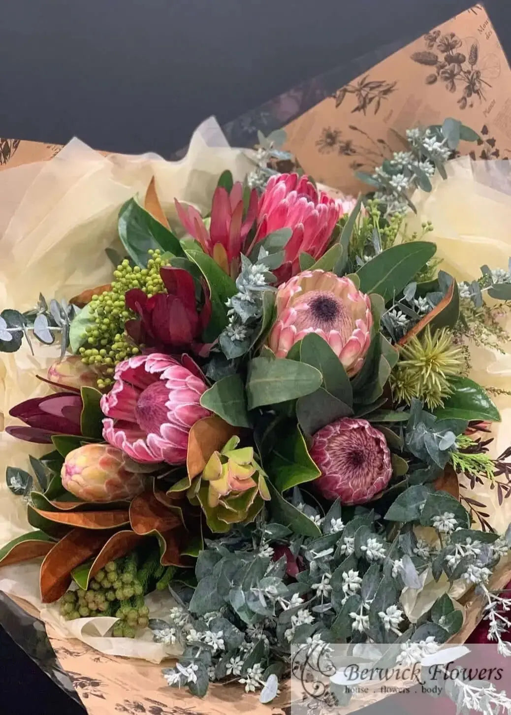 Bouquet of flowers with protea and eucalyptus on patterned paper