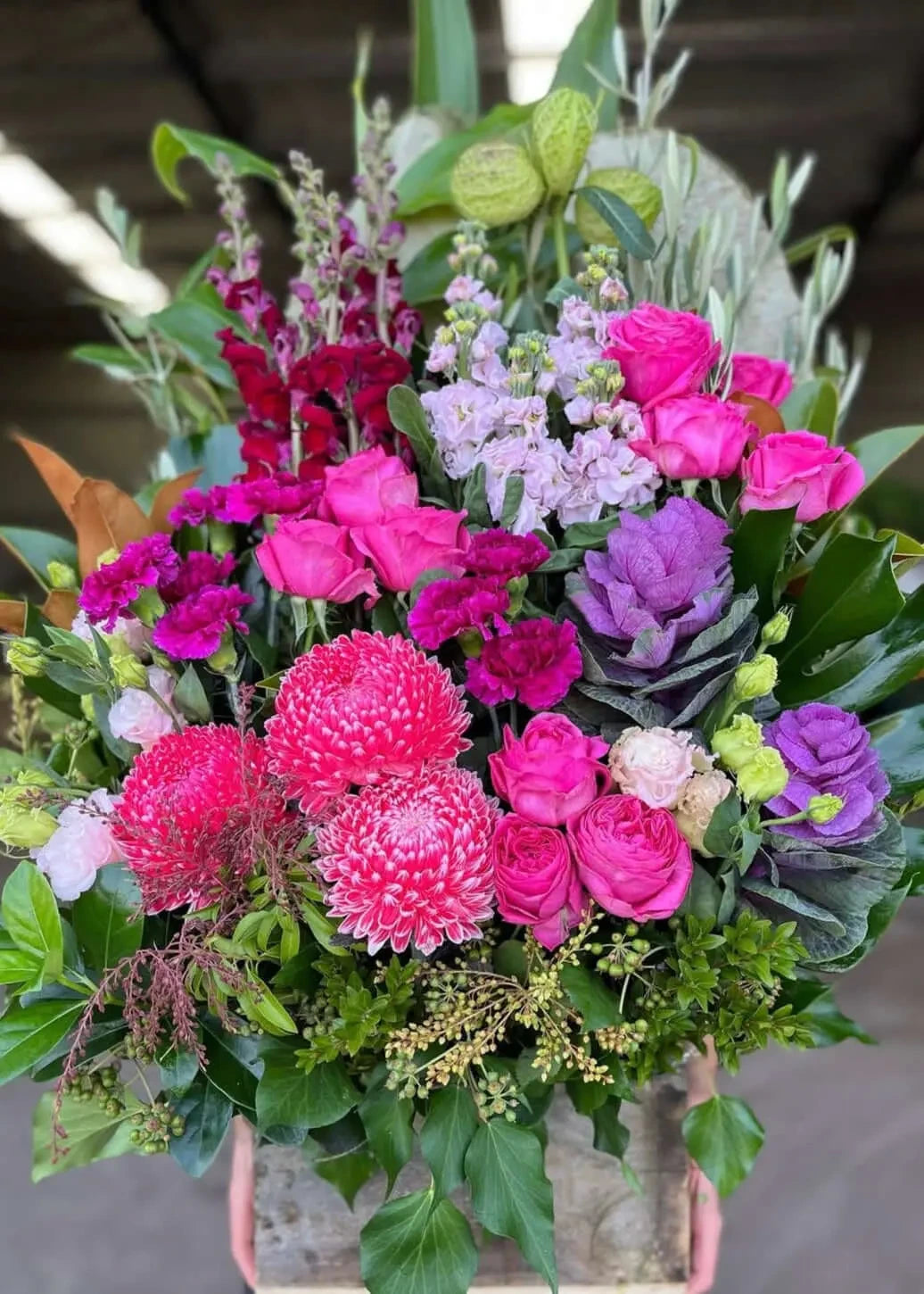 Bouquet of colorful flowers including pink, purple, and green in a clear vase.