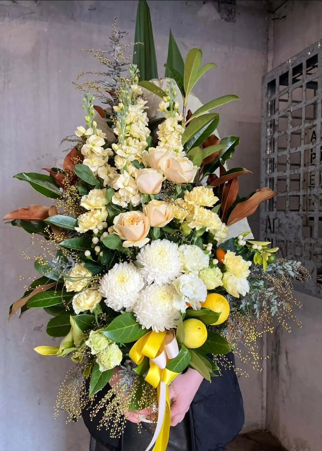 Spring flower arrangements featuring yellow and white blooms, greenery, and decorative elements by Berwick Flowers.