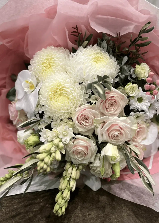 Bouquet of flowers with white, pink, and green colors on a pink background