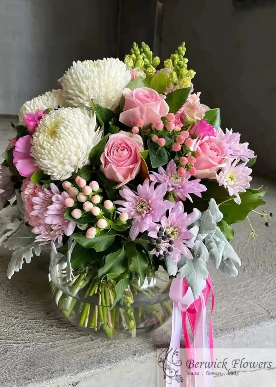 Bouquet of flowers with pink and white ribbons on a textured surface