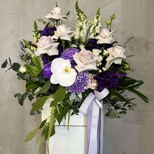Luxury flower delivery Berwick arrangement featuring roses, orchids, and seasonal greenery in a decorative box.