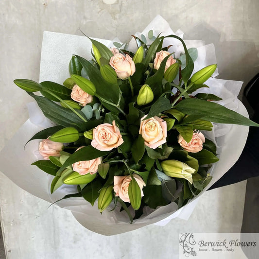 Bouquet of pink roses and green leaves on a light gray background