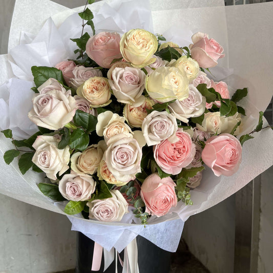 luxury rose bouquet featuring soft pink and cream roses arranged beautifully with greenery