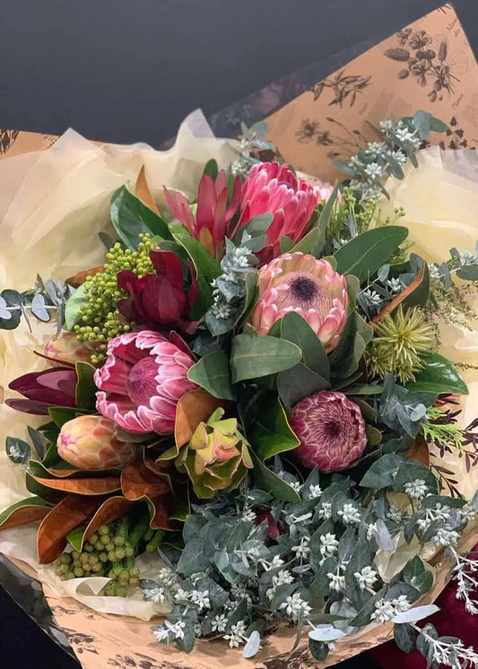Bouquet of flowers with protea and eucalyptus on patterned paper